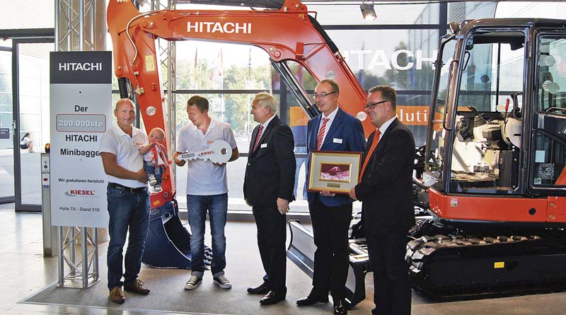 Bernd, Ben und Ralf Riedlmeier (v.l.n.r.) mit Gerd Ettwig (Kiesel Vertriebsleiter Kompaktmaschinen), Bernhard Ebner (Kiesel Vertriebsrepräsentant) und Joep van den Maagdenberg (Hitachi Assistant Manager) bei der Schlüsselübergabe auf der GaLaBau 2014. (Foto: DBU/Heiko Metzger)
