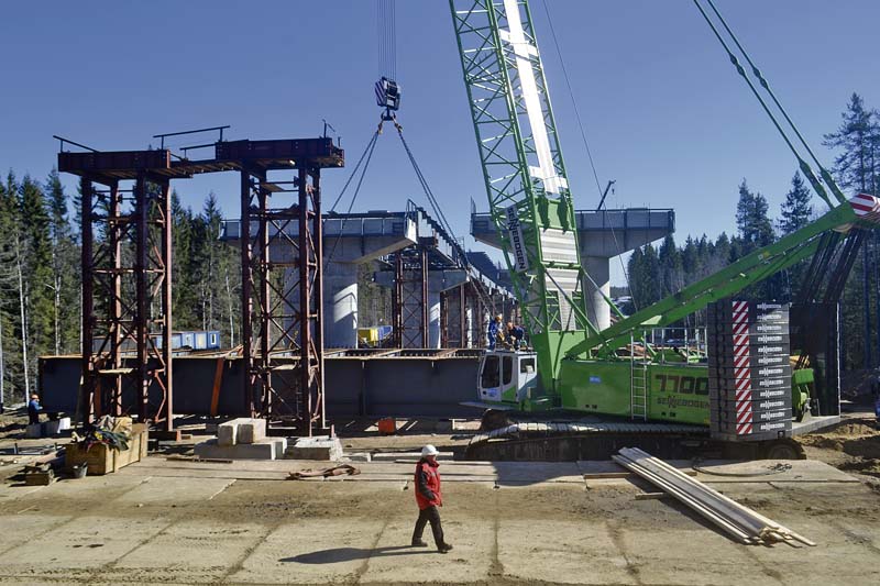 Fertigteile bis zu 100 t Gewicht müssen beim Bau einer 400 m langen Autobahnbrücke mit einen Sennebogen 7700 Raupenkran präzise platziert werden.  (Foto: Sennebogen Maschinenfabrik GmbH)