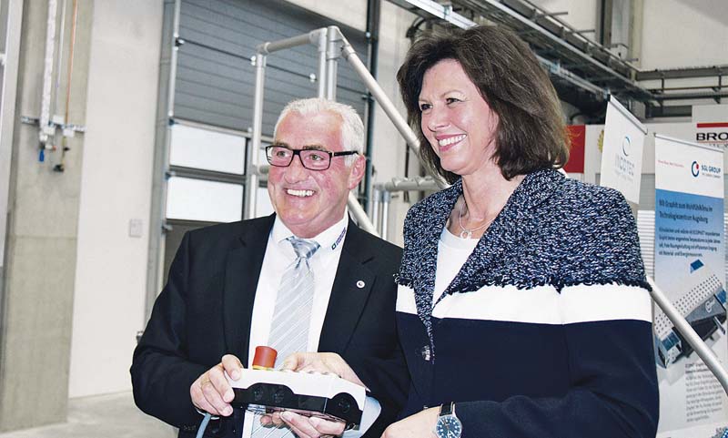 Bayerns Wirtschafts- und Technologieministerin Ilse Aigner und Geschäftsführer Ferdinand Munk drücken auf Start für den Erfolg der Günzburger Steigtechnik im Technologiezentrum Augsburg. (Foto: Günzburger Steigtechnik)