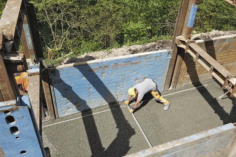 Die Sohle der Baugrube wird zunächst vorverdichtet und mit einer Ausgleichsschicht versehen. Danach werden ein Planum von 10 bis 20 Zentimeter Höhe und eine 20 Zentimeter dicke Schicht Einkornbeton aufgebracht.    (Foto: thyssenkrupp Infrastructure)